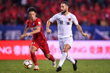 Spanish soccer player Mario Suarez, right, of Guizhou Hengfeng passes the ball against a player of Chongqing SWM in their 15th round match during the 2018 Chinese Football Association Super League (CSL) in Chongqing, China, 1 August 2018