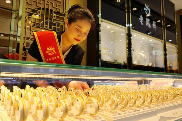 店員が中国東部安寧省華北市の宝石店で金の装飾品を展示 2018年6月26日 — ストック写真