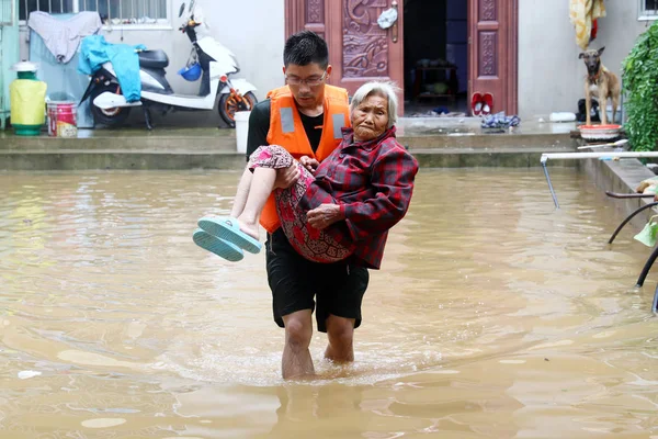 2018年8月19日 中国东部安徽省淮北市杜集区一个村庄 一名中国救援人员在遭受今年第18号台风 伦比亚 的特大暴雨袭击后 在洪水中疏散了一名老年妇女 — 图库照片