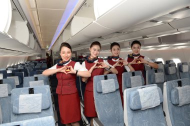 Flight attendants pose in a economy-class cabin of an Airbus A350-900 jet plane of Air China after it arrived at the Chengdu Shuangliu International Airport in Chengdu city, southwest China's Sichuan province, 15 August 2018 clipart