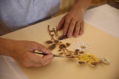 Chinese craftsman Ding Xisen creates a wheat straw painting at his workshop in Boli town, Qingdao city, east China's Shandong province, 15 July 2018 clipart