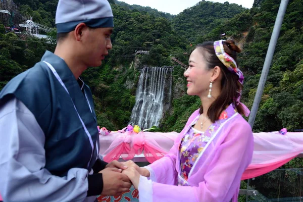伝統的な衣装を着た中国の若者は 中国のバレンタインデーとしても知られるQixiフェスティバルを記念して 清の龍西景勝地の崖に沿って1 314の マグピー で飾られたガラス底の橋の上で演奏します — ストック写真