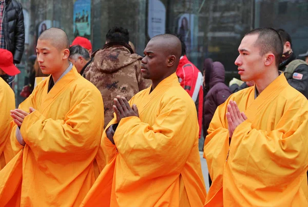 2015年1月27日 中国中部の湖北省浙州市のラバ フェスティバルで ワンダ プラザの広場で シャオリン寺院の留学生と中国人僧侶がラバのお粥を地元住民に配布する準備をしています — ストック写真