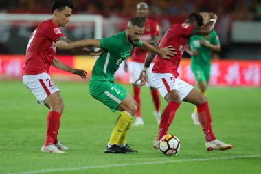 Spanish soccer player Mario Suarez, center, of Guizhou Hengfeng passes the ball against players of Guangzhou Evergrande Taobao in their 12th round match during the 2018 Chinese Football Association Super League (CSL) in Guangzhou city, south China's 