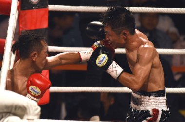 Raymond Poon Kai-ching of Hong Kong, right, competes against Ryo Narizuka of Japan in their men's light-flyweight bout during the 