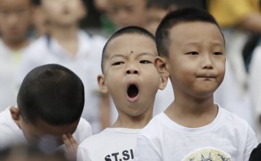 A young student yawns as he and other students attend a flag-raising ceremony of a new semester at a primary school in Guiyang city, southwest China's Guizhou province, 27 August 2018.  clipart