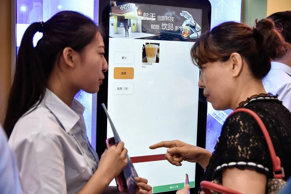 訪問者は 2018 日世界ロボット会議 Wrc 2018 中国の間にセルフ サービスのマシンの知能ロボットで作った牛乳お茶を注文します — ストック写真