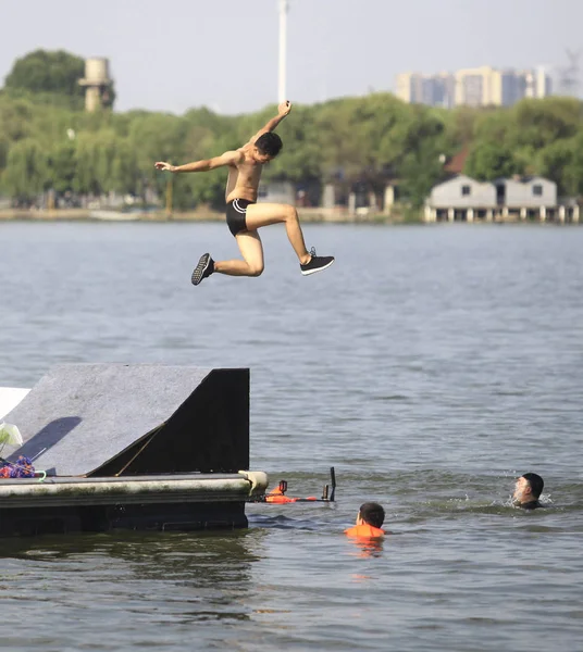 2018 日中国中央部の湖北省武漢市で毎年恒例の 湖ジャンプ フェスティバル中板の道からの暑い天気の中で冷やすため東湖に飛び込む参加者 — ストック写真