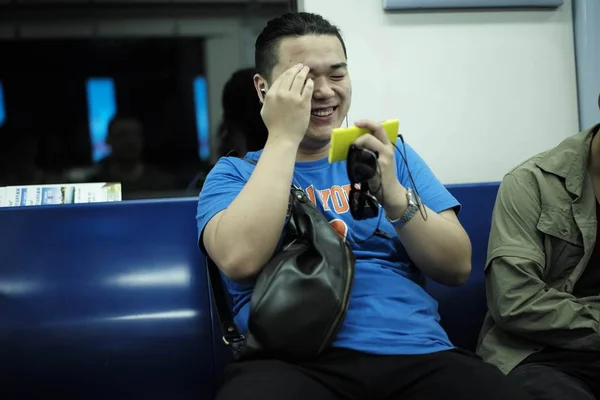 Пассажир Смеется Использует Свой Смартфон Серфинга Интернете Поезде Метро Пекине — стоковое фото