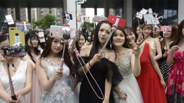 Chinese internet celebrities take selfies at a new online celebrity base in Wuhan city, central China's Hubei province, 8 May 2018 clipart