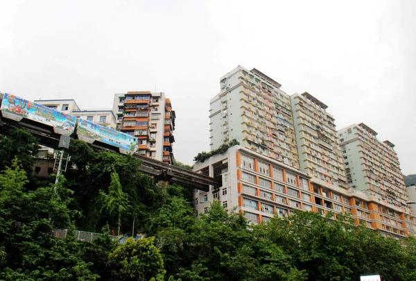 2号轻轨列车通过重庆市丽子坝站一栋楼 — 图库照片