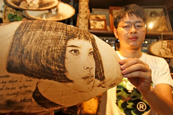 27歳の中国人男性ペン牙は 中国北西部陝西州西安市の彼の店で焼画の芸術作品を表示します 月2018 — ストック写真