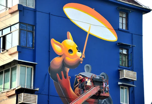 アルゼンチンの女性アーティストは 2018 中国の四平路に住宅建築に子供や動物ケアをテーマにした壁画を作成します — ストック写真