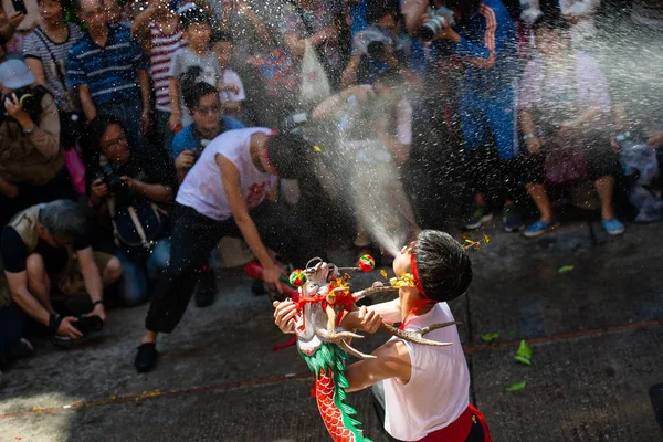 実行者は 2018 日中国 マカオでお釈迦様の誕生日を祝うために酒に酔ったドラゴン祭り中に酒に酔ったドラゴン ダンスを実行する彼の口からビールをスプレーします — ストック写真