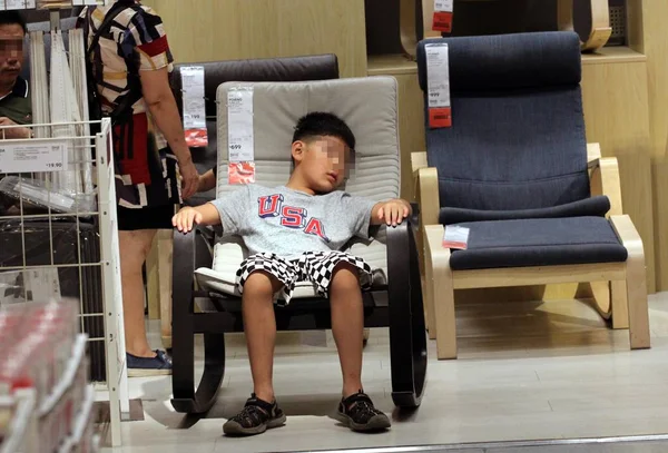 Молодий Китайський Хлопчик Який Втечі Спека Лежить Кріслі Магазині Ikea — стокове фото