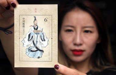 A Chinese collector shows a commemorative stamp to mark Qu Yuan, a well-known Chinese poet and minister of the State of Chu, at a branch of China Post during the Dragon Boat Festival, also known as Duanwu Festival, in Suzhou city, east China's Jiangs clipart