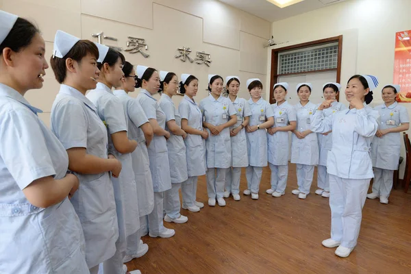 Kvinnliga Sjuksköterskor Bita Ätpinnar Att Öva Leende För Patienter Att — Stockfoto