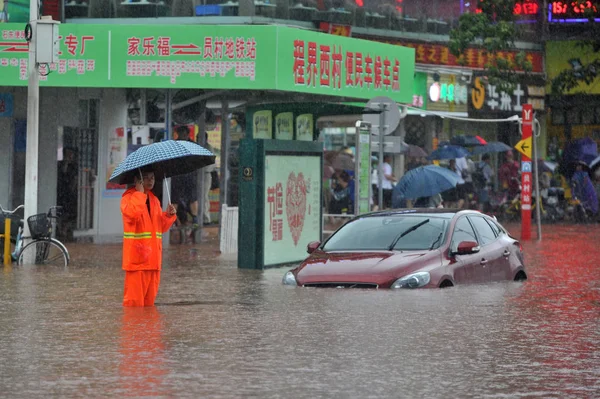 中国南部の広東省広州市で今年4回目の台風 台風エウィニアル による豪雨の後 浸水した道路に沈んだ車の近くに中国人労働者が立っている 2018年6月8日 — ストック写真