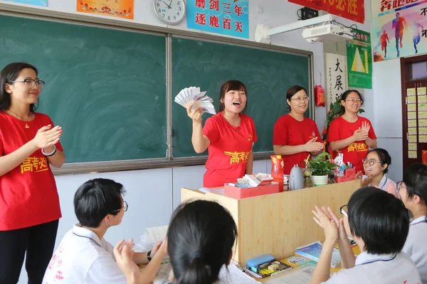 中国の教師は Gaokao としても知られている 毎年恒例の国立大学入試に座り 中国の河北省の Hengshui 市の中学校2中学校で幸運なお金として5元紙幣を与える前に その生徒たちに話します — ストック写真