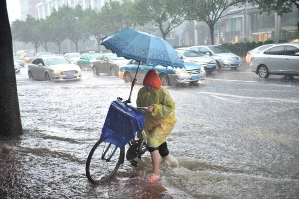 2018年6月8日 中国南方广东省广州市 一名当地居民在台风Ewiniar引发的特大暴雨中 在被洪水淹没的公路上用雨伞自防 — 图库照片