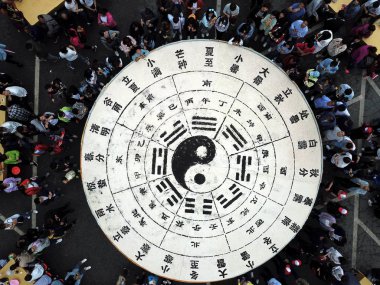 Tourists share 3.5 tons of tofu in the shape of a Tai Chi diagram during a Taoist festival at the Laojun Mountain scenic spot in Luoyang city, in central China's Henan province, 19 May 2018.   clipart