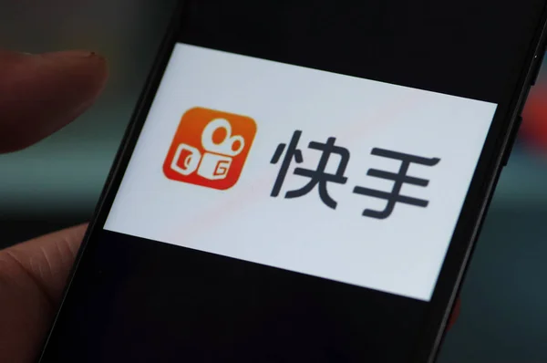 File 中国の携帯電話ユーザーは 中国東部の山東省 江南市の短いビデオプラットフォームクワイテクノロジーのKuaishouアプリのロゴを見て 2018年3月8日 — ストック写真