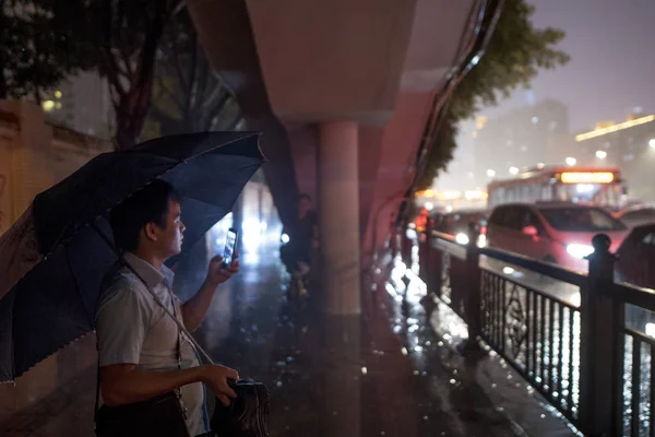 2018年5月2日 中国南部の広東省広州市で大雨の中 バスを待つ地元住民が傘を持って身を守る — ストック写真