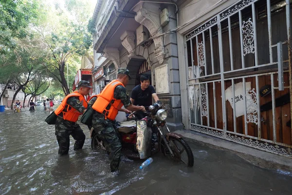 中国の兵士が 2018 日台風 Ampil 中国天津市で 台風による洪水でバイクを押してください — ストック写真