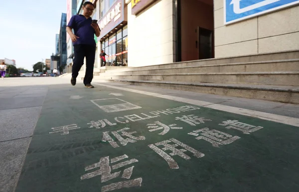 6月5日 在中国西北陕西省西安市 一名行人走在手机人行道上 用智能手机 — 图库照片