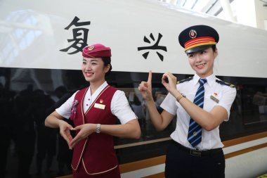 Chinese train attendants pose in front of a 