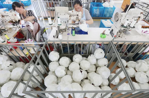 中国の労働者は 2018 日中国東部の江蘇省海門市のスポーツ用品会社の工場で 2018 Fifa ワールド カップのサッカー ボールを製造します — ストック写真