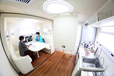 People visit the dining area of a luxury recreational vehicle (RV) designed by German industrial designer Luigi Colani in Changzhou city, east China's Jiangsu province, 10 June 2018 clipart