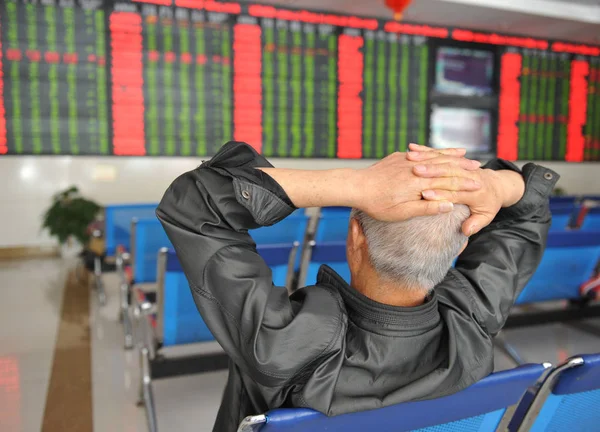 2018 日中国東部の安徽省阜陽市の証券会社の家で 赤の価格上昇 と価格下落のため緑の株式の価格を見て懸念している中国語の投資家 — ストック写真