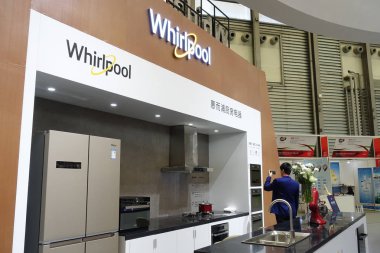 A man visits the stand of American home appliance manufacturer Whirlpool Corporation during the Appliance & Electronics World Expo 2018 (AWE 2018) in Shanghai, China, 9 March 2018.  clipart