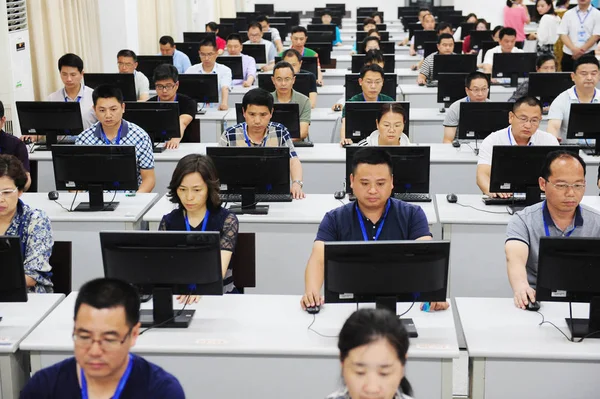 中国の教師は 2018年6月14日 中国東部安寧省合肥市の安寧大学のキャンパスのコンピュータ上で 2018年国立大学入試試験に出席する学生のテストペーパーをマークします — ストック写真