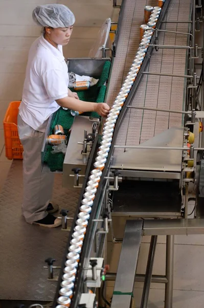 2018年5月29日 北京に本拠を置く飲料ブランド の加工 瓶詰め工場で 中国人労働者が組み立てライン上でオレンジソーダの缶の生産をチェックする — ストック写真