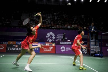 Jia Yifan, left, of China returns a shot as she and Chen Qingchen compete against Misaki Matsutomo and Ayaka Takahashi of Japan in their women's doubles badminton final during the 2018 Asian Games, officially known as the 18th Asian Games and also kn clipart