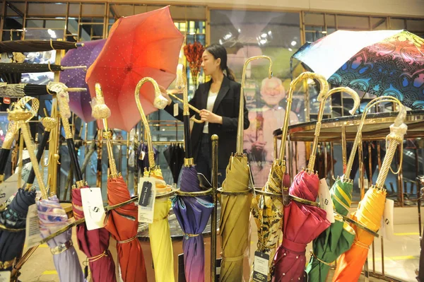 中国中部の湖北省武漢市のショッピングモールの店でユニークな棒を持つ高価な傘を買う顧客 2018年5月10日 — ストック写真