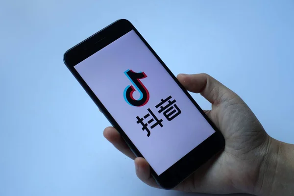 ----ein handybenutzer öffnet die mobile app von tik tok, einer überseeischen iteration der kurzen video-app douyin, der beijing bytedance technology co ltd auf seinem smartphone in ji 'nan stadt in der ostchinesischen provinz shandong, 10. Mai 2018 — Stockbild Ein Handybenutzer Öffnet Die Mobile App Von Tik Tok Einer — Stockfoto