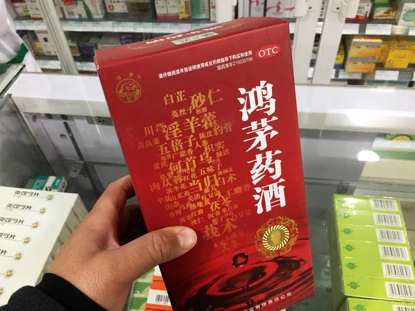 2018年4月16日 上海の薬局でヘルスケアワイン ホンマオ を見せるお客様 — ストック写真
