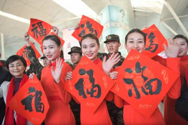 Stewardesses display the Chinese character fu, which means 