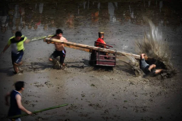 客家の人々 が泥にまみれたお祝い時に水浸しのフィールドを介して古代の一般的な関功ダッシュ中国の黄金の像を運ぶ 清華同方町チャン Juhe 村で春の農地を目覚めさせることの中国の村人たち — ストック写真