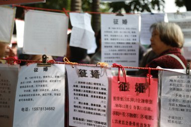 Chinese parents display personal information of their unmarried children to help them look for girlfriends and boyfriends at the matchmaking corner in Nanning city, south China's Guangxi Zhuang Autonomous Region, 10 March 2018. clipart