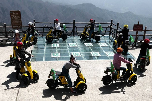 ボランティア中国中部の河南省洛陽市の Laojun 山の崖の端に沿ってガラスの通路に電動自転車に乗って 2018 — ストック写真