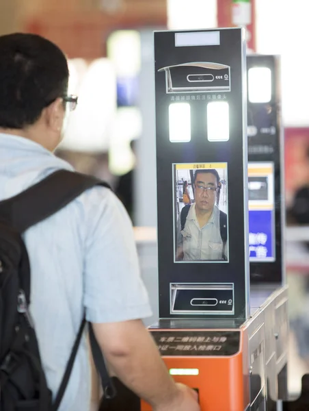 中国旅客が 2017 日中国中央部の湖北省武漢市の鉄道駅でのチェックインに顔認識システムによってスキャンされた彼の顔 — ストック写真