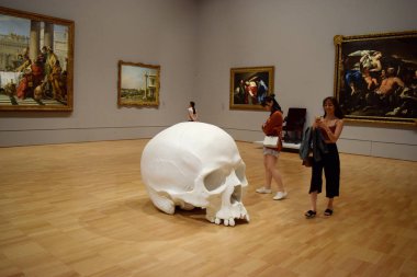 Visitors view 'Mass', an artwork of 100 larger-than-life skulls by Australian sculptor Ron Mueck, on display during the NGV Triennial art exhibition at the National Gallery of Victoria art museum in Melbourne Victoria, Australia, 31 March 2018 clipart