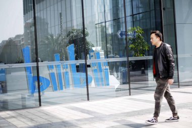 A pedestrian walks past Costa Coffee's first cafe inspired by Bilibili, a leading Chinese video-sharing streaming website themed around anime, comic and game fandom in Shanghai, China, 5 March 2018. clipart