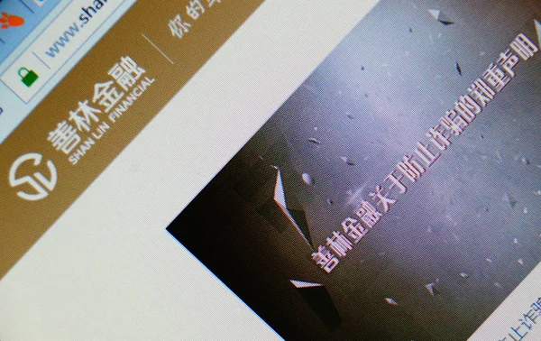 中国のネチゼンは 違法な資金調達に関与しているシャンリン ファイナンシャルのウェブサイトを 中国天津の彼のコンピュータで2018年4月12日に閲覧します — ストック写真