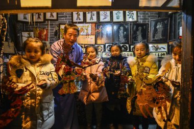 60-year-old Chinese folk artist Chen Shouke teaches children to perform shadow play or shadow puppetry, also known as shadow puppet, in Tai'erzhuang district, Zaozhuang city, east China's Shandong province, 1 March 2018 clipart