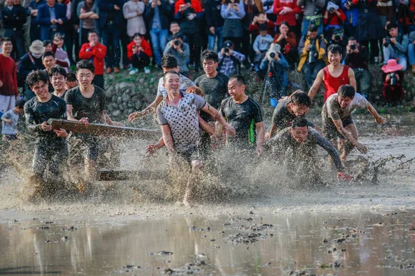 客家の人々 の中国の村人たちが 目覚め 清華同方 Juhe 村の春 農地の泥にまみれたお祝いに水浸しのフィールドとスプラッシュ水に古代中国一般的な関功の黄金の像を運ぶ — ストック写真